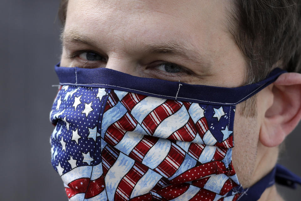 Drew Grande, 40, of Cranston, R.I., wears a protective mask over of concerns about the coronavirus outside his home, Wednesday, April 15, 2020, in Cranston. Grande began a log for contact tracing on his smartphone at the beginning of April, after he heard Rhode Island Gov. Gina Raimondo urge residents to start out of concern about the spread of the coronavirus. “If I’m going out to the store, I’ll put the date, what store I went to, and then the time I was there,” he said (AP Photo/Steven Senne)