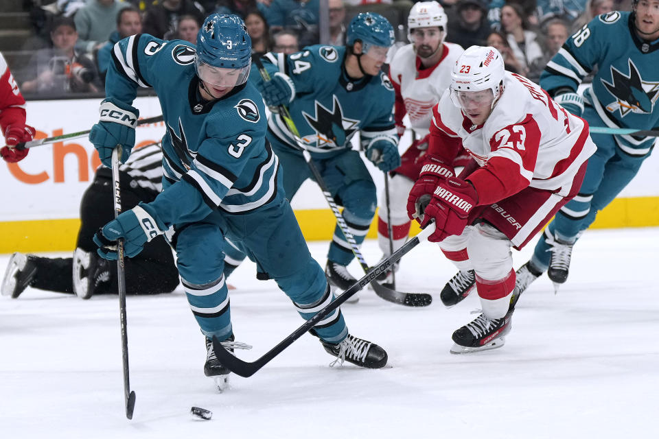 San Jose Sharks defenseman Henry Thrun (3) moves the puck near Detroit Red Wings left wing Lucas Raymond (23) during the second period of an NHL hockey game Tuesday, Jan. 2, 2024, in San Jose, Calif. (AP Photo/Tony Avelar)
