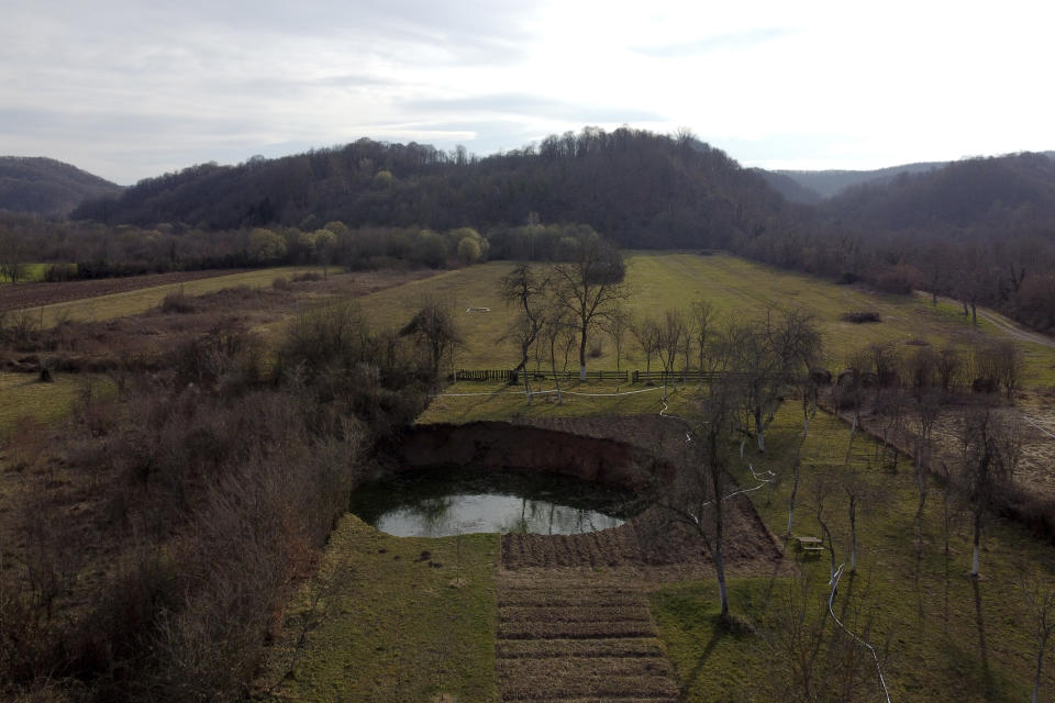 This aerial photo shows a sinkhole in the village of Mececani, central Croatia, Thursday, March 4, 2021. A central Croatian region about 40 kilometers (25 miles) southwest of the capital Zagreb is pocked with round holes of all sizes, which appeared after December's 6.4-magnitude quake that killed seven people and caused widespread destruction. Scientists have been flocking to Mecencani and other villages in the sparsely-inhabited region for observation and study. (AP Photo/Darko Bandic)