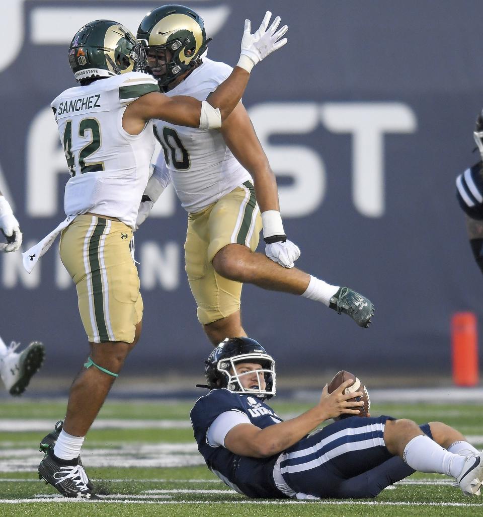 Colorado State linebackers Justin Sanchez (42) and Chase Wilson (30) celebrate after sacking Utah State quarterback Cooper Legas, bottom right, during the first half of an NCAA college football game Saturday, Oct. 7, 2023, in Logan, Utah. | Eli Lucero/The Herald Journal via AP