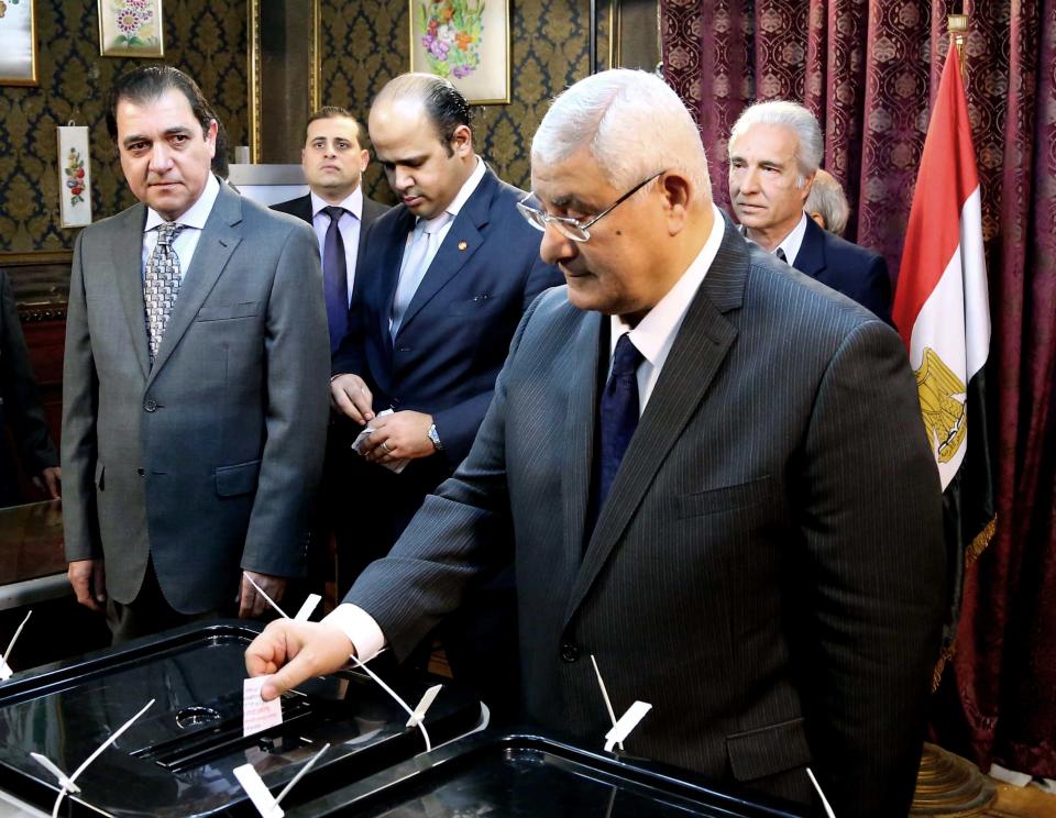 FILE - In this Jan. 14, 2014, file photo released by the Middle East News Agency, the Egyptian official news agency, interim President Adly Mansour casts his vote at a polling station in Cairo, Egypt. Mansour, in a televised address to the nation on Sunday, Jan. 19, sought to reassure young Egyptians that they will not be sidelined. (AP Photo/Middle East News Agency, File)