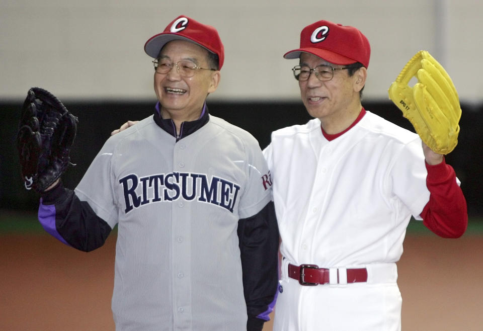 FILE - Japanese Prime Minister Yasuo Fukuda, right, poses with Chinese Premier Wen Jiabao after they played catch in the gymnasium of Beijing's Diaoyutai State Guesthouse on Dec. 29, 2007. Japan and China on Thursday, Sept. 29, 2022, mark the 50th anniversary of the 1972 normalization of their ties. (AP Photo/Greg Baker, Pool, File)