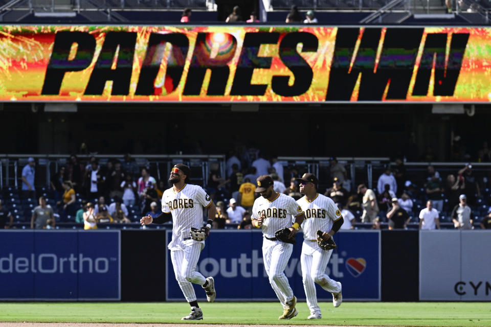 San Diego Padres right fielder Fernando Tatis Jr. (23), left, center fielder Trent Grisham (1), center, and left fielder Juan Soto (22) leave the field after the Padres defeated the Colorado Rockies 3-2 in a baseball game Wednesday, Sept. 20, 2023, in San Diego. (AP Photo/Denis Poroy)