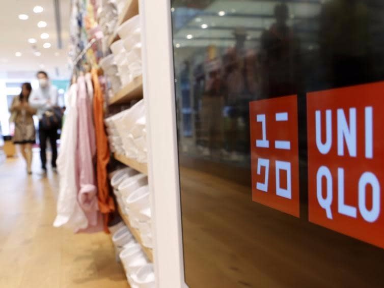 Shoppers walk at Fast Retailing Co's Uniqlo casual fashion chain store in Tokyo April 10, 2013. REUTERS/Yuya Shino