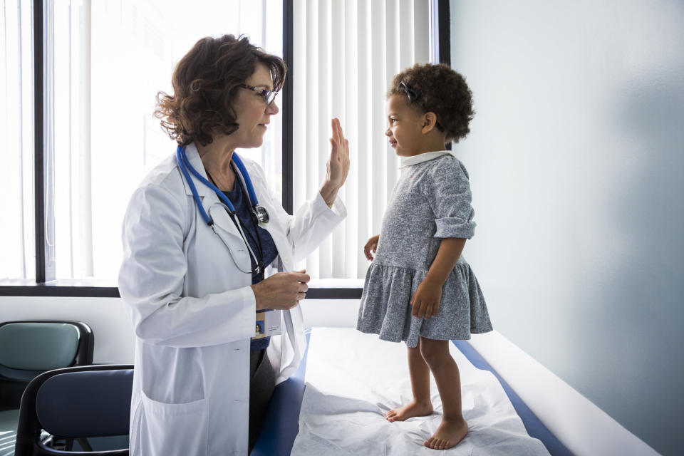 A doctor treating a Black child