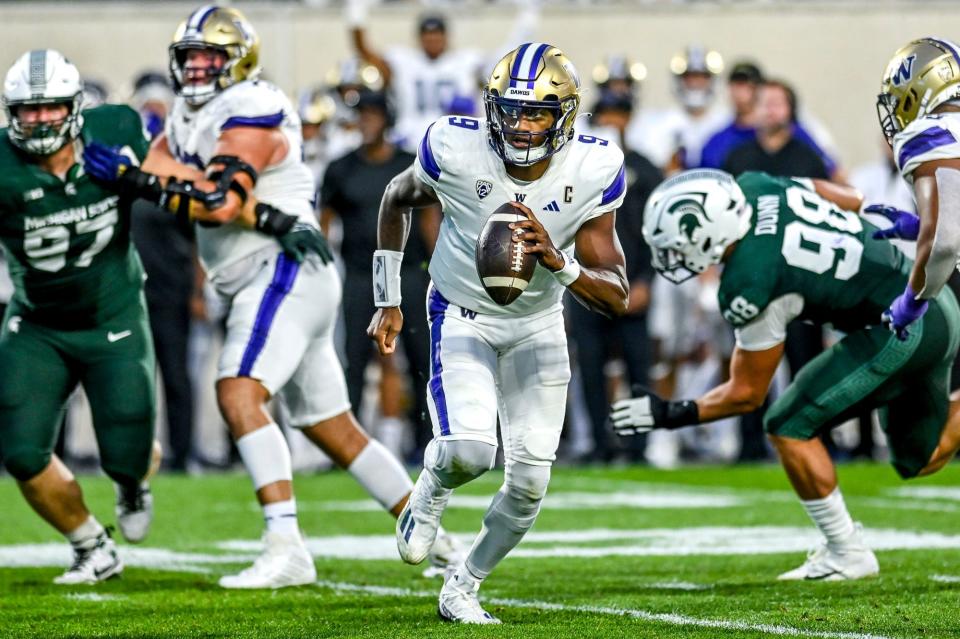Washington quarterback Michael Penix Jr. runs the ball while looking to pass against Michigan State during their game on Sept. 16, 2023, at Spartan Stadium.