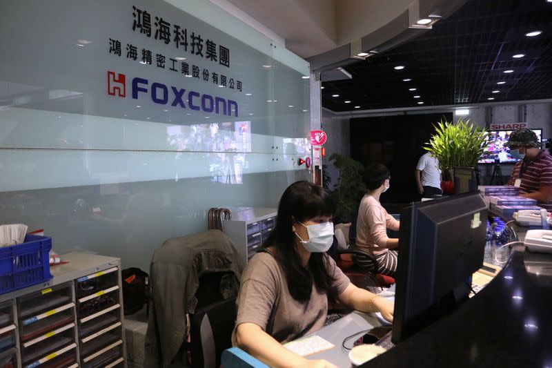 Staff wear masks to protect themselves from coronavirus disease (COVID-19), while listening to the annual general meeting at the lobby of Foxconn's office in Taipei,