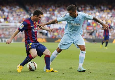 Barcelona's Lionel Messi (L) controls the ball against Granada FC's Javi Marquez during their Spanish first division soccer match at Nou Camp stadium in Barcelona September 27, 2014. REUTERS/Gustau Nacarino