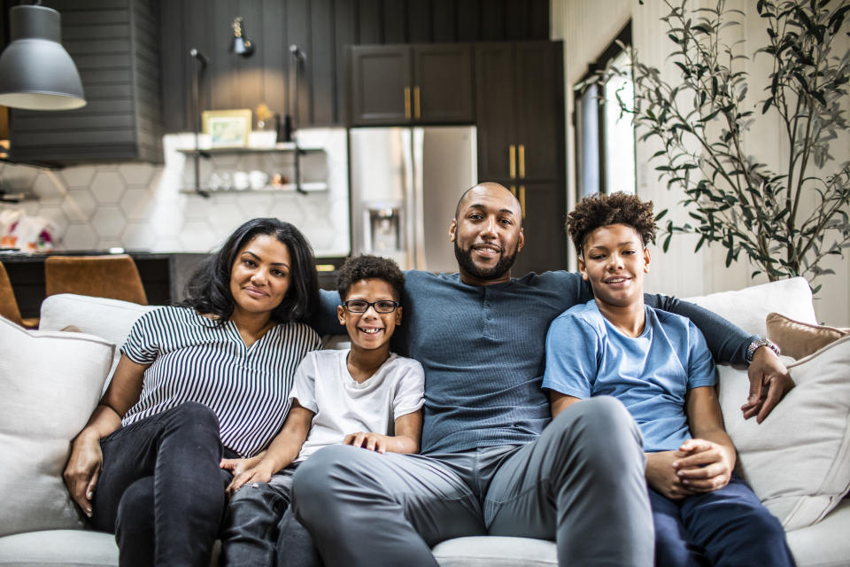 Portrait of family on sofa in residential living room