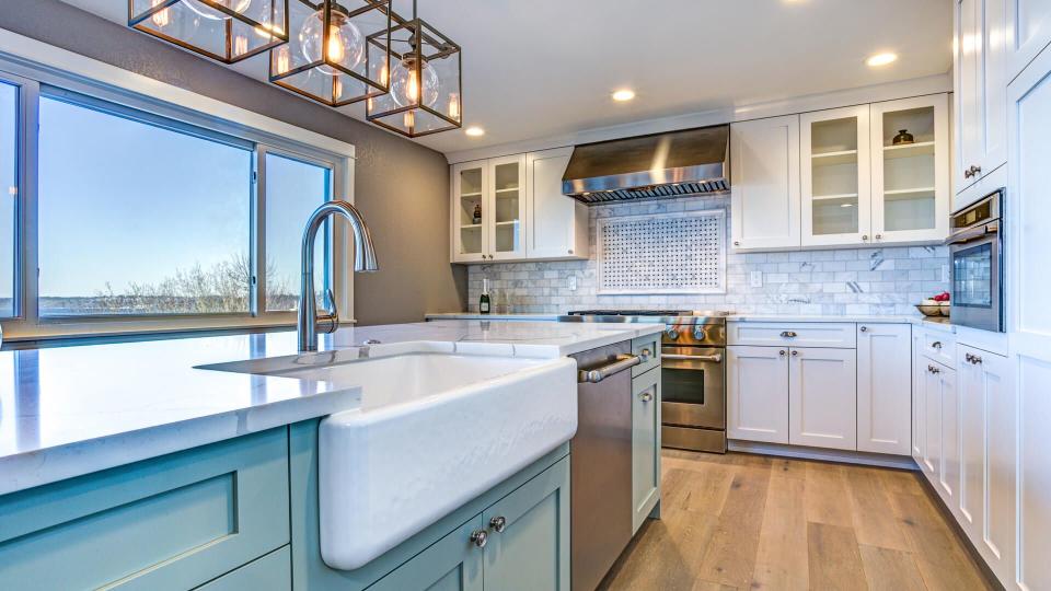 Beautiful kitchen room with green island and farmhouse sink.