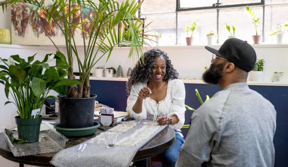 Victoria Campbell Osborne laughed with Sean Byers Sr. as she sold cologne at Kinship Cafe. Campbell Osborne said she does business about once a week at the cafe, which as at risk of being demolished for parking.