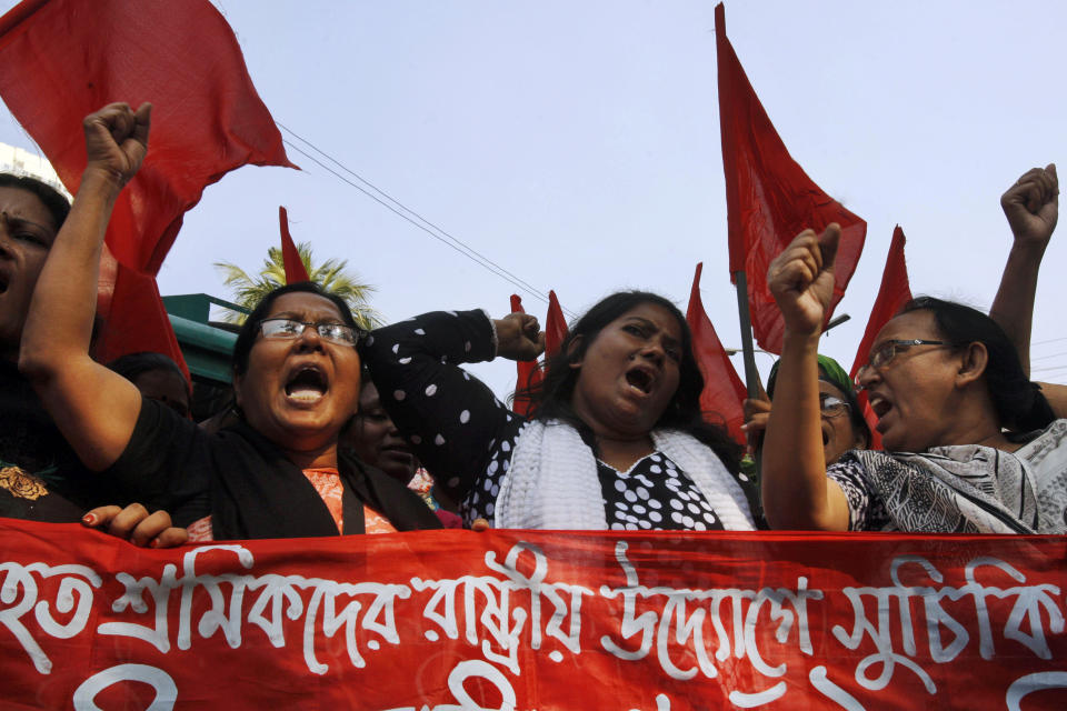 Bangladeshi garment workers shout slogans as they participate in a protest to mourn the death of the victims of a fire in a garment factory in Dhaka, Bangladesh, Friday, Nov. 30, 2012. Hundreds of garment workers protested Friday outside the Bangladeshi factory where 112 people were killed by the fire, demanding compensation for their lost salaries. The banner reads: "We demand financial help for the workers." (AP Photo/Pavel Rahman)