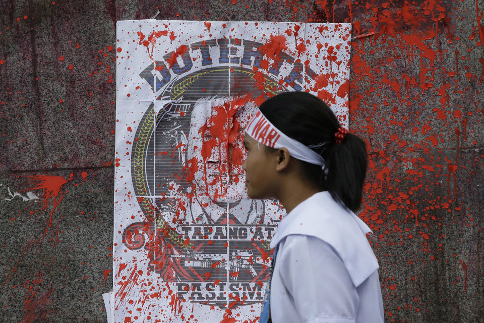 <p>A Filipino student activist passes by a photo of Philippine President Rodrigo Duterte after red paint was thrown at it during a rally as they call for free education near the Malacanang presidential palace in Manila, Philippines, Feb. 23, 2017. (Photo: Aaron Favila/AP) </p>