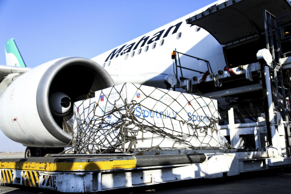 In this photo released by Imam Khomeini Airport City, Russian-made Sputnik V coronavirus vaccines are being unloaded at the Tehran's Imam Khomeini International Airport, Thursday, Feb. 4, 2021. Iran on Thursday received its first batch of foreign-made coronavirus vaccines as the country struggles to stem the worst outbreak of the pandemic in the Middle East. (Saeed Kaari/IKAC via AP)