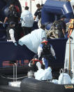 A Border Force vessel brings a group of people thought to be migrants into the port city of Dover, southern England, Sunday Aug. 9, 2020. Many migrants have used small craft during the recent hot calm weather to make the dangerous journey from northern France, to cross the busy shipping lanes of The Channel to reach Britain. (Yui Mok/PA via AP)