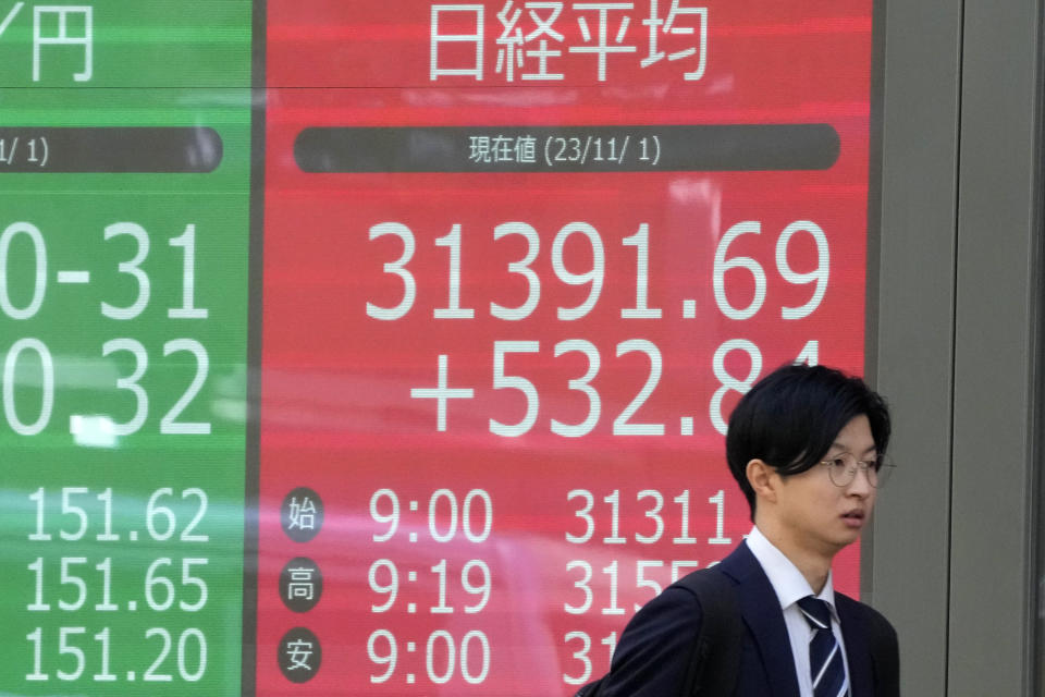 A pedestrian passes an electronic stock board showing Japan's Nikkei 225 index, seen in red, at a securities firm Wednesday, Nov. 1, 2023 in Tokyo. Asian shares were mostly higher Wednesday after Wall Street advanced to claim back some of the ground it gave up in another losing month. (AP Photo/Shuji Kajiyama)