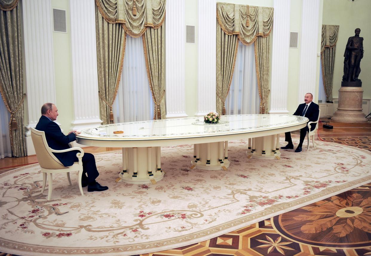 Putin speaks Aliyev from across a long table.