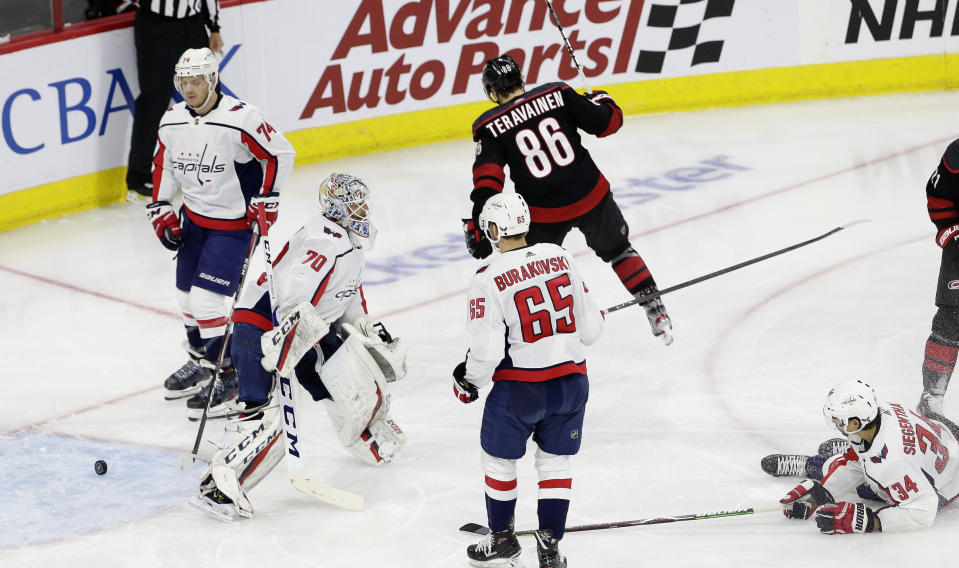 Carolina Hurricanes' Teuvo Teravainen (86), of Finland, reacts following a goal against Washington Capitals goalie Braden Holtby (70) during the second period of Game 6 of an NHL hockey first-round playoff series in Raleigh, N.C., Monday, April 22, 2019. Capitals' Andre Burakovsky (65), of Austria, and John Carlson (74) look on with Capitals' Jonas Siegenthaler (34), of the Czech Republic. (AP Photo/Gerry Broome)