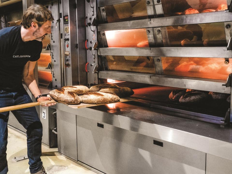 Uliks Fehmiu bakes bread in one of Pain D'Avignon's oversized ovens. More than 60 million loaves have been baked there since 1992.