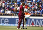 West Indies batsman Dwayne Smith walks off the field after he was caught out by India's wicketkeeper MS Dhoni during their Cricket World Cup match in Perth, March 6, 2015. REUTERS/David Gray