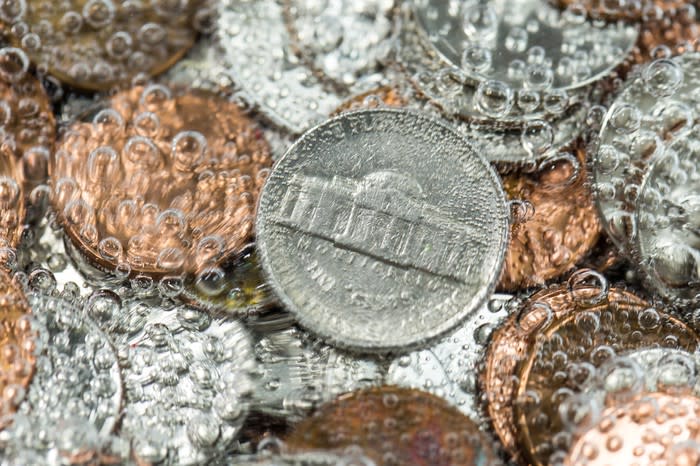 A pile of coins in carbonated water