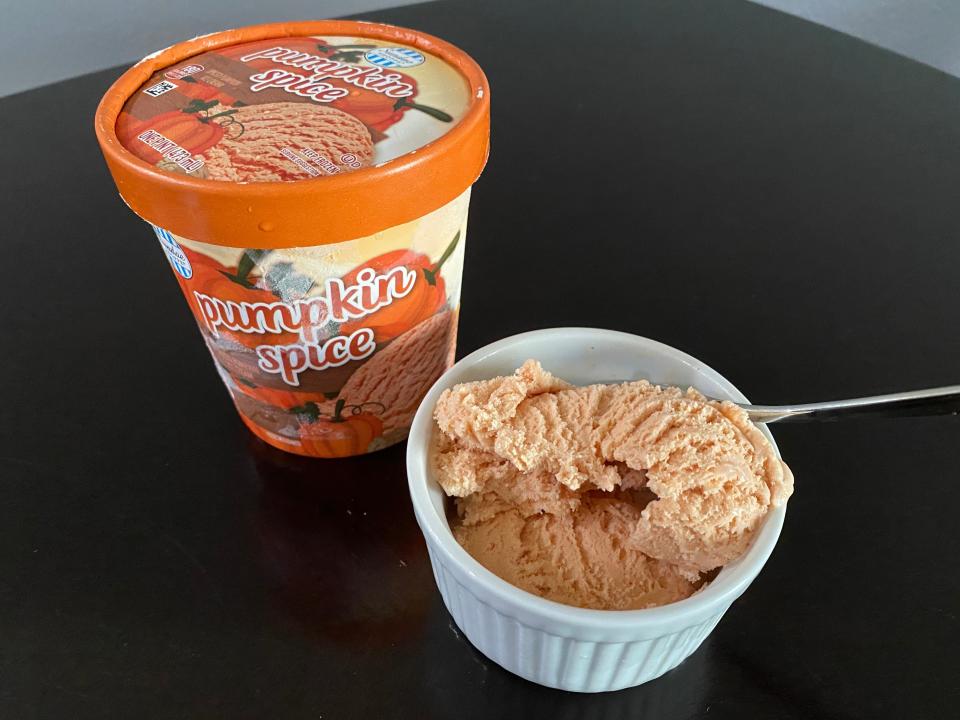 small white bowl of pumpkin spice ice cream beside orange carton from aldi