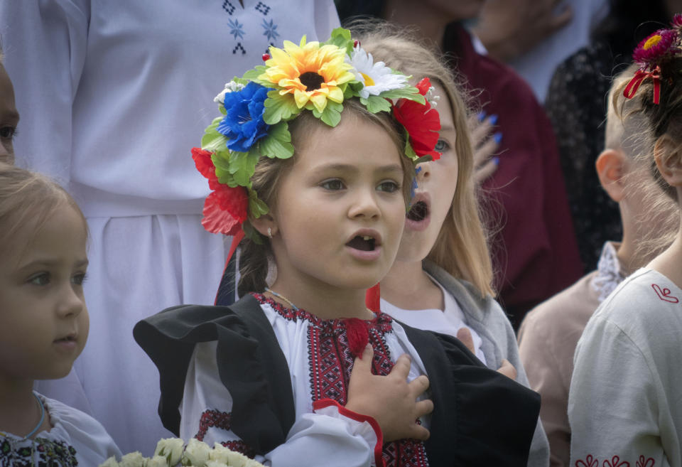 Escolares cantan el himno nacional en la ceremonia de regreso a clases en Bucha, Ucrania, 1 de setiembre de 2023. El inicio del año escolar se festeja como Día del Conocimiento. (AP Foto/Efrem Lukatsky)