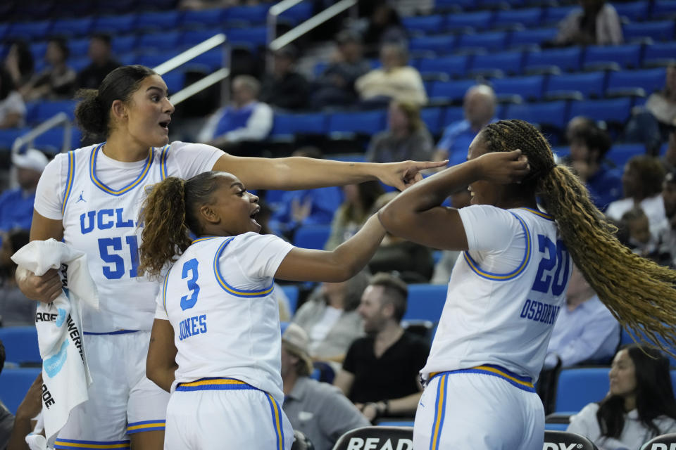 UCLA center Lauren Betts (51), guard Londynn Jones (3), and guard Charisma Osborne (20) celebrate from the sideline after a point during the second half of an NCAA college basketball game against UC Riverside in Los Angeles, Thursday, Nov. 9, 2023. (AP Photo/Ashley Landis)