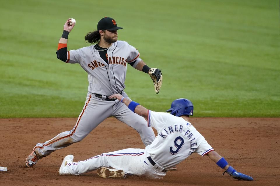 San Francisco Giants shortstop Brandon Crawford throws to first to complete the double play after forcing Texas Rangers' Isiah Kiner-Falefa (9) at second in the third inning of a baseball game in Arlington, Texas, Tuesday, June 8, 2021. Willie Calhoun was out at first. (AP Photo/Tony Gutierrez)