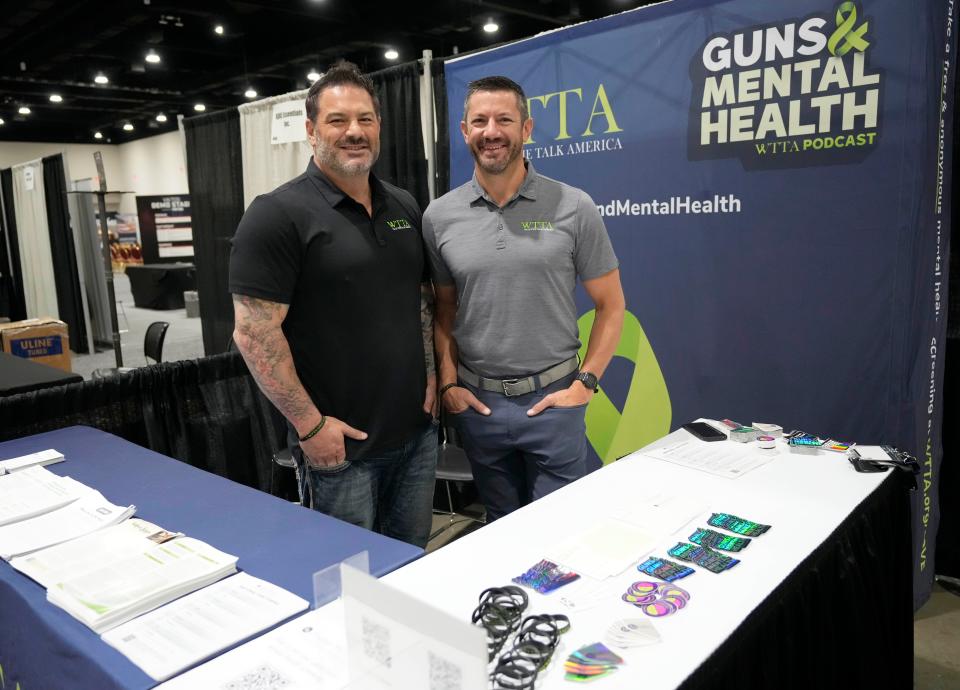 Michael Sodini (left), a former gun importer, and Jake Wiskerchen, a therapist and gun owner, at a booth for a group called Walk the Talk America, founded to discuss mental health concerns among gun owners. They were at the Concealed Carry & Home Defense Expo in Milwaukee in September 2023.