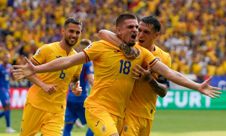 <span>Romania's Razvan Marin is embraced after his penalty equaliser against Slovakia.</span><span>Photograph: Themba Hadebe/AP</span>