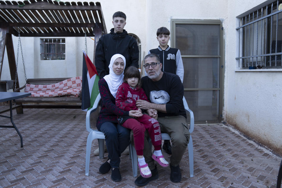 The Palestinian Tamimi family pose for a photo with their son Wisam, 17 rear left, a released prisoner under the Israel Hamas cease fire agreement last week, at the family house in the West Bank village of Nabi Saleh, northwest of Ramallah, Thursday, Nov. 30, 2023. The release of Palestinian prisoners under the Israel-Hamas cease-fire agreement last week has touched nearly everyone in the occupied West Bank, where 750,000 Palestinians have been arrested since 1967. In negotiations with Israel to free hostages in Hamas captivity in Gaza, the militant group has pushed for the release of high-profile prisoners. But experts say most Palestinians passing through Israel's ever-revolving prison door are young men arrested in the middle of the night for throwing stones and firebombs in villages near Israeli settlements. (AP Photo/Nasser Nasser)