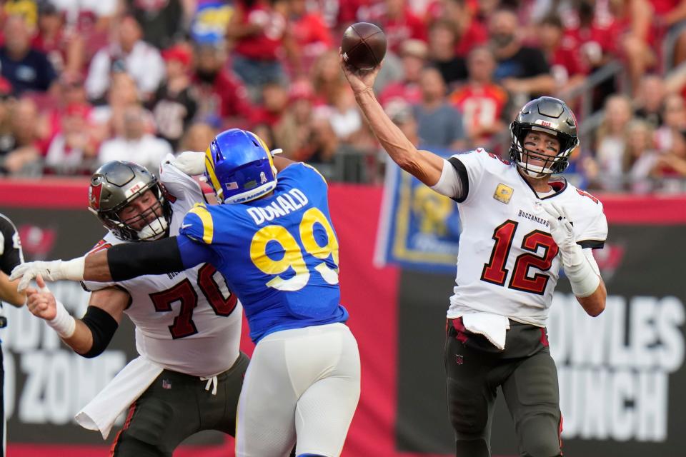 Tampa Bay Buccaneers quarterback Tom Brady (12) throws a pass as Los Angeles Rams defensive tackle Aaron Donald (99) tries to get past offensive tackle Robert Hainsey (70) during the first half of an NFL football game between the Los Angeles Rams and Tampa Bay Buccaneers, Sunday, Nov. 6, 2022, in Tampa, Fla. (AP Photo/Chris O'Meara)