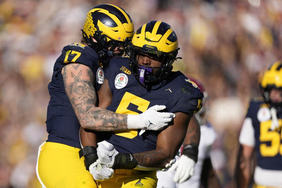 Michigan defensive end Josaiah Stewart (5) celebrates with defensive end Braiden McGregor (17) after Stewart's tackle on Alabama quarterback Jalen Milroe (4) during the first half in the Rose Bowl CFP NCAA semifinal college football game Monday, Jan. 1, 2024, in Pasadena, Calif. (AP Photo/Ryan Sun)