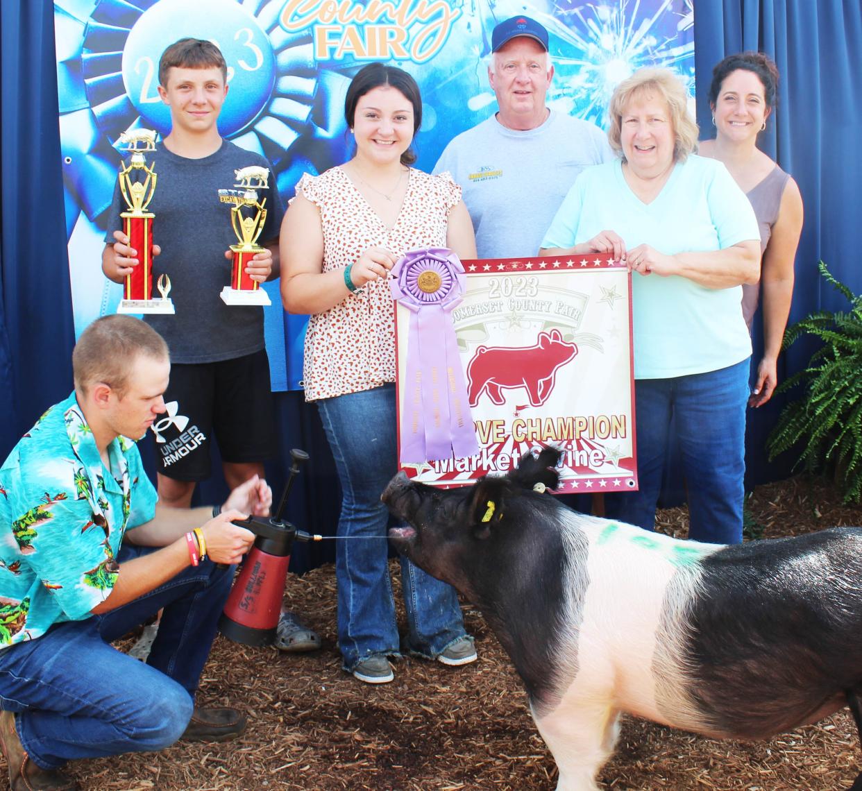 Lydia Sheeler of Somerset sold her reserve grand champion swine for $22 a pound to Krause Service LLC, represented here by Bill and Susan Krause of Somerset, during the junior livestock sale at the Somerset County Fair on Saturday. Also shown are from left: Lydia's brother, Sam Sheeler, and her mother, Julia Sheeler on far right, and Caleb Antram kneeling.