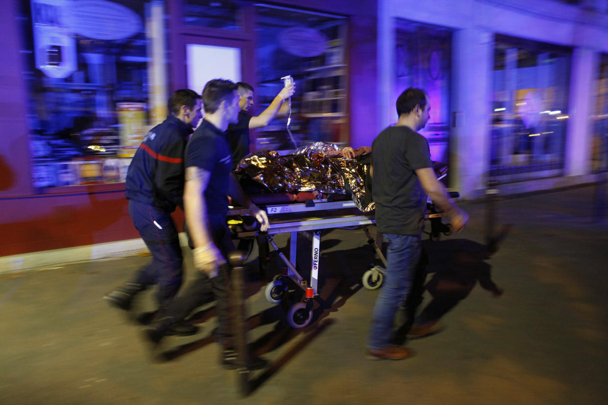 FILE - A person is evacuated after a shooting, outside the Bataclan theater in Paris, Nov. 14, 2015. The historic trial in Paris of 20 men suspected of critical roles in the Islamic State massacres that killed 130 people in 2015 has ended this week with verdicts against the defendants in France's worst peacetime attack expected on Wednesday June 29. (AP Photo/Thibault Camus, File)