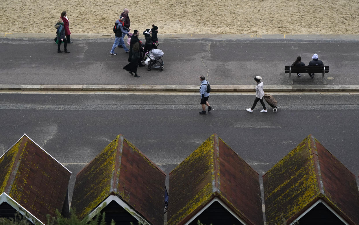 People walk along the sea front on Bournemouth beach in Dorset. The UK could see the mildest New Year's Eve on record, with sunshine in some areas, after what is likely to be one of the dullest Decembers ever. But despite the sun, revellers in some parts of the UK will have to brace for heavy showers in the evening. Picture date: Friday December 31, 2021. (Photo by Andrew Matthews/PA Images via Getty Images)