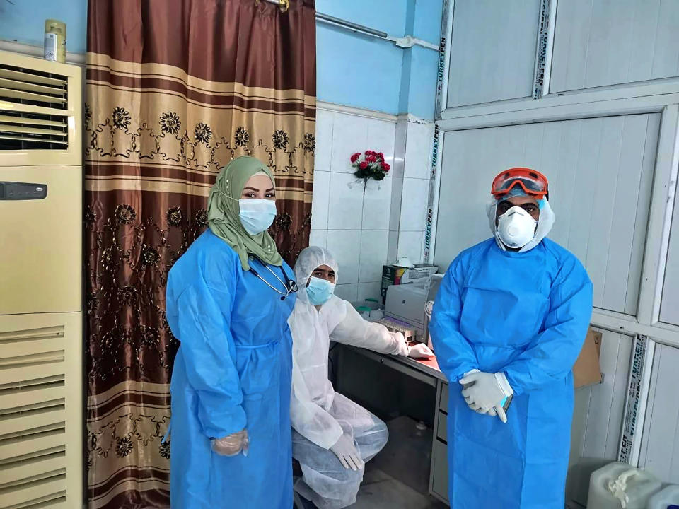 This May 13, 2020, picture provided by Dr. Marwa al-Khafaji shows the doctor posing with colleagues after coming back to work following 20 days in isolation after she tested positive for the coronavirus, at a hospital in Karbala, Iraq. Dr. Marwa al-Khafaji’s homecoming from a hospital isolation ward was tainted by spite. Someone had barricaded her family home’s gate with a concrete block. The message from the neighbors was clear: She had survived coronavirus, but the stigma of having had the disease would be a more pernicious fight. (AP Photo)