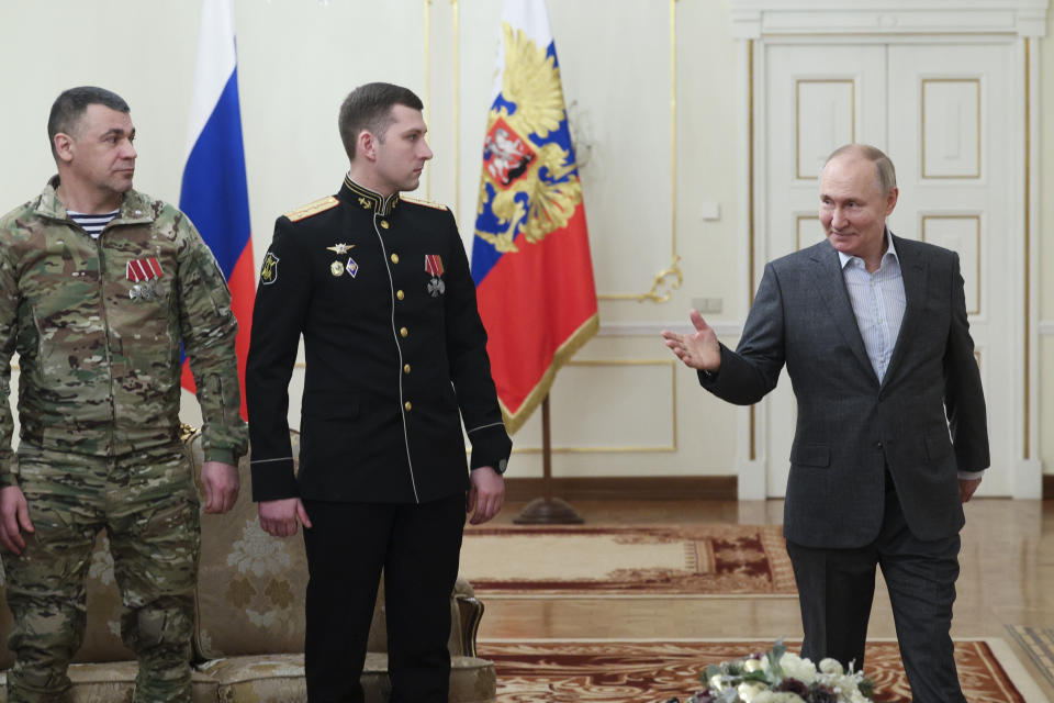 Russian President Vladimir Putin, right, gestures as he speaks to Russian servicemen, participants of the special military operation in Ukraine during a meeting at the Novo-Ogaryovo State residence outside Moscow, Russia, Monday, Jan. 1, 2024. (Gavriil Grigorov, Sputnik, Kremlin Pool Photo via AP)