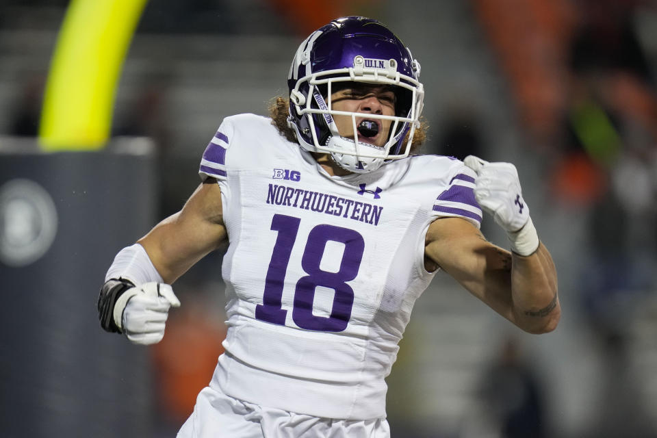 Northwestern defensive back Garner Wallace celebrates after recovering a fumble by Illinois and running in a touchdown during the second half of an NCAA college football game Saturday, Nov. 25, 2023, in Champaign, Ill. (AP Photo/Erin Hooley)