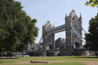 FILE - A man sunbathes backdropped by Tower Bridge in London, July 19, 2022. Scientists said the heat wave in England and Wales on July 18 and 19 was definitely turbocharged by human-caused climate change, according to a study released Thursday, July 28, by the World Weather Attribution. (AP Photo/Tony Hicks, File)