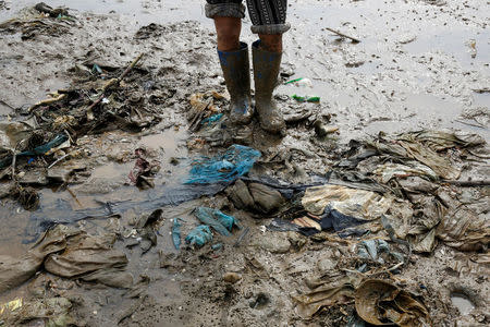 A person is seen at the beach covered with plastic waste in Thanh Hoa province, Vietnam June 4, 2018. REUTERS/Kham