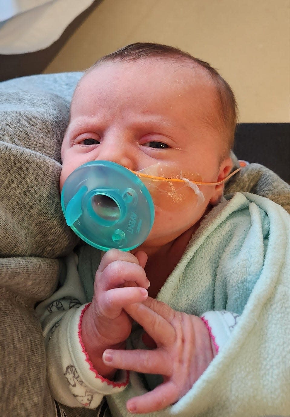 Hadley opens her eyes with a pacifier in the Aurora NICU.