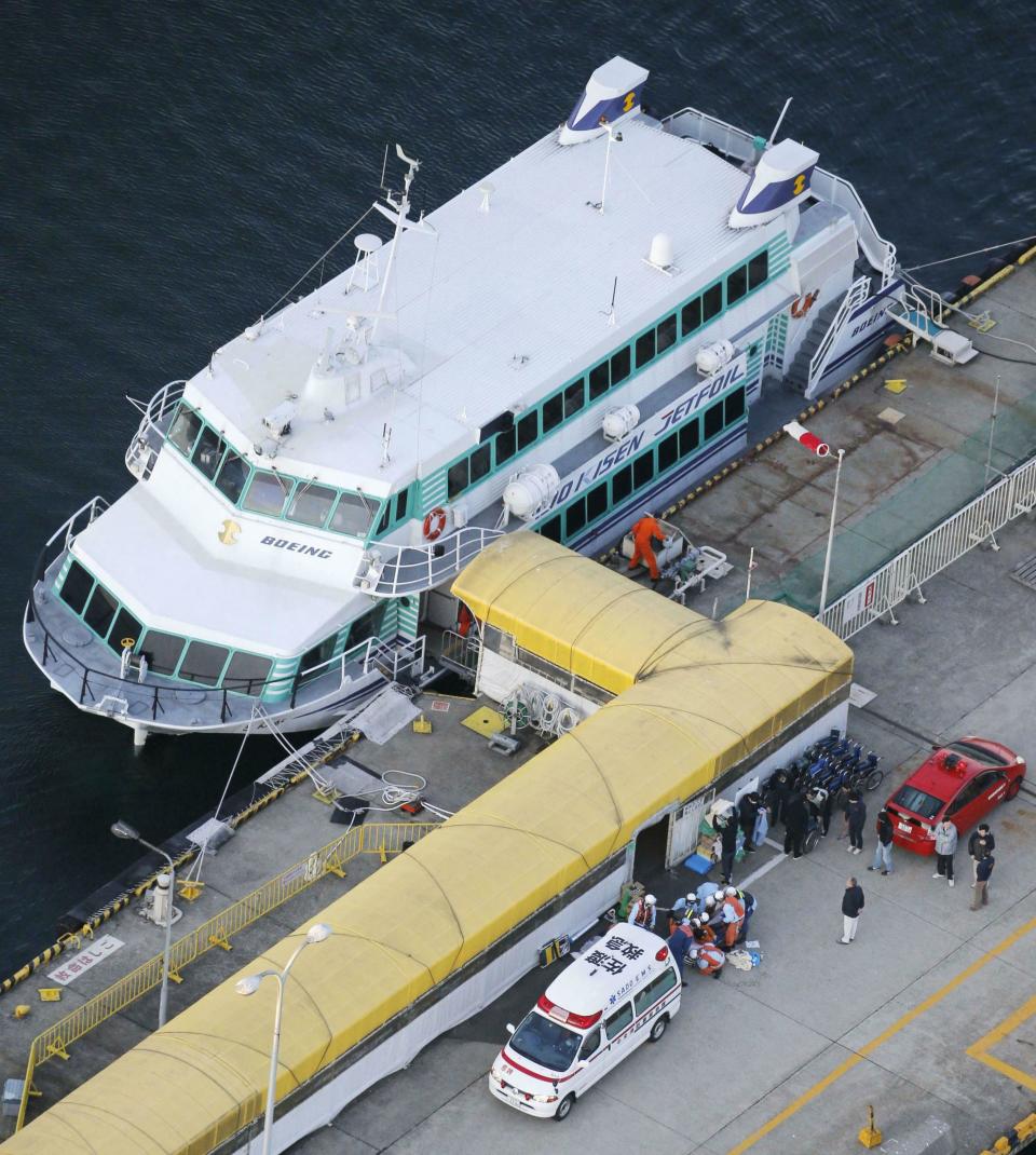 In this Saturday, March 9, 2019, photo, firefighters, bottom, prepare to taken injured passengers to a hospital at a port in Sado city, Niigate prefecture. A ferry collided with what apparently was a marine animal off a Japanese island on Saturday, injuring more than 80 people, local media reported. The accident happened just after noon off Sado Island, Kyodo News agency reported, citing Japan's coast guard. (Kyodo News via AP)