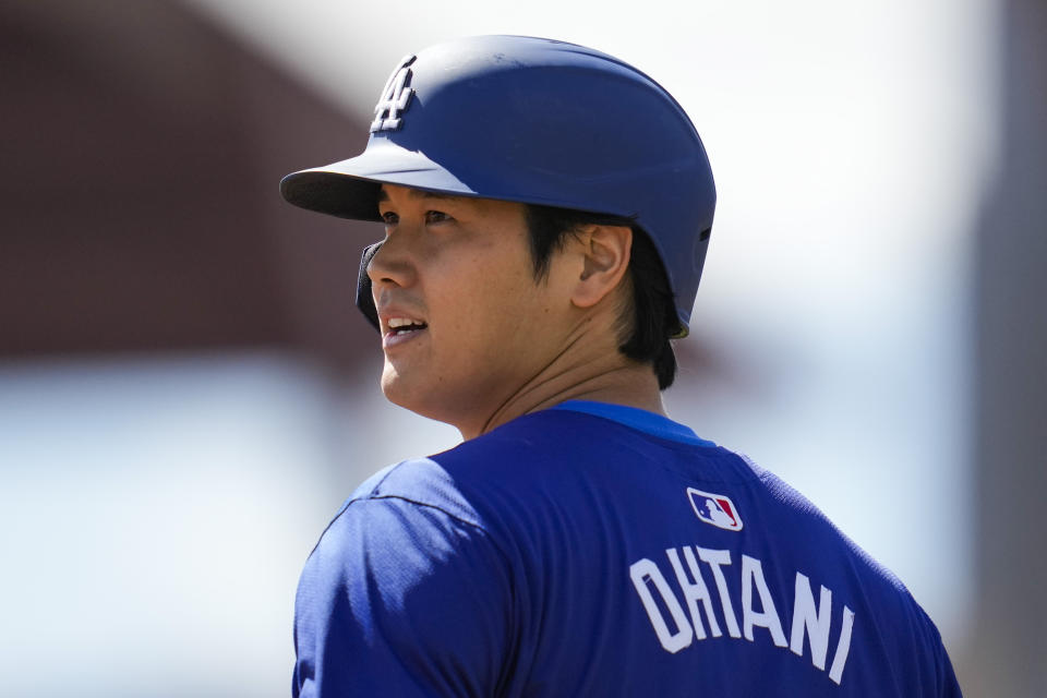 FILE - Los Angeles Dodgers designated hitter Shohei Ohtani stands on third base during the first inning of a spring training baseball game against the Colorado Rockies in Phoenix, Sunday, March 3, 2024. Ohtani received a record-breaking $700 million contract from the Dodgers within months of his second major elbow operation.(AP Photo/Ashley Landis, File)