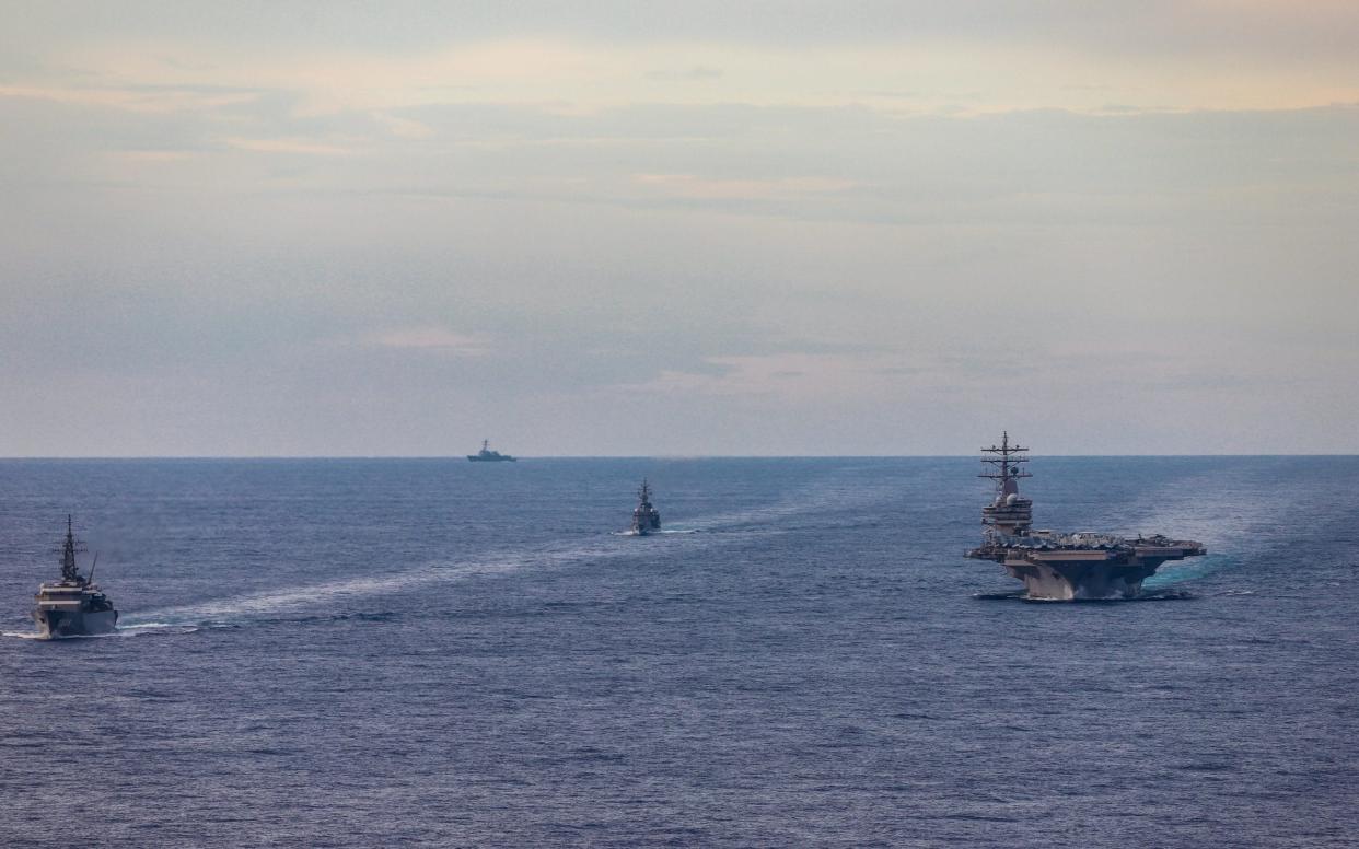 Japan Maritime Self-Defense Force training ships conduct a passing exercise with Nimitz-class nuclear-powered aircraft carrier USS Ronald Reagan in the South China Sea - Reuters