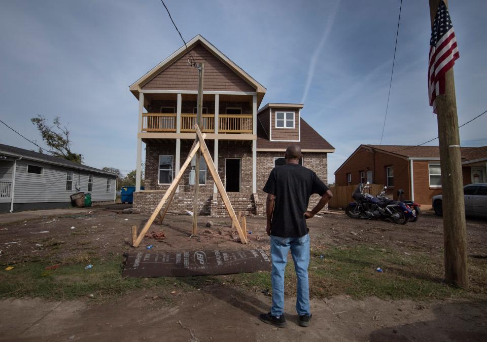 Sam Brown takes a moment to look at his home Thursday, Nov. 5, 2020 in Nashville, Tenn. Brown decided to serve as his own contractor to rebuild his demolished home after a tornado ripped through the neighborhood in March 2020. In the past year, Brown has had to stop and restart his construction process as he struggles to finance his rebuilding efforts.