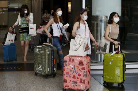 South Korean visitors arriving from Seoul are seen wearing masks at Hong Kong Airport in Hong Kong, China, June 9, 2015. REUTERS/Bobby Yip