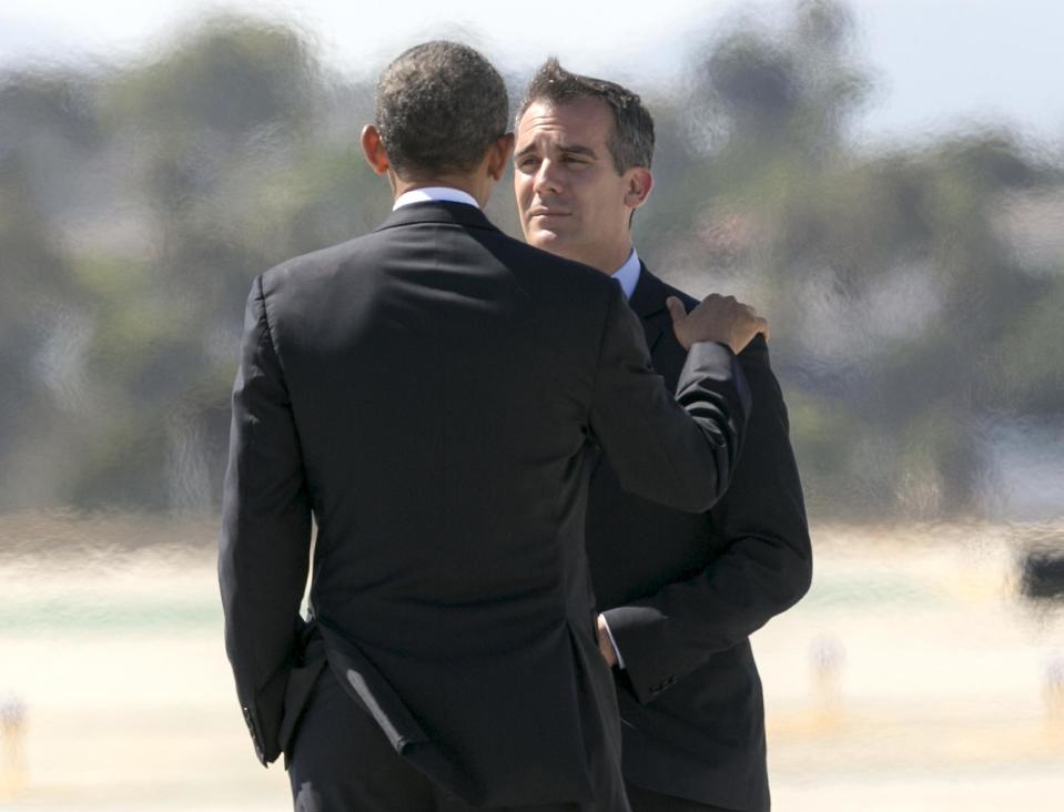 President Barack Obama, left, is greeted by Los Angeles Mayor Eric Garcetti as he steps off of Air Force One at Los Angeles International Airport Tuesday, Aug. 6, 2013, in Los Angeles. (AP Photo/Damian Dovarganes)