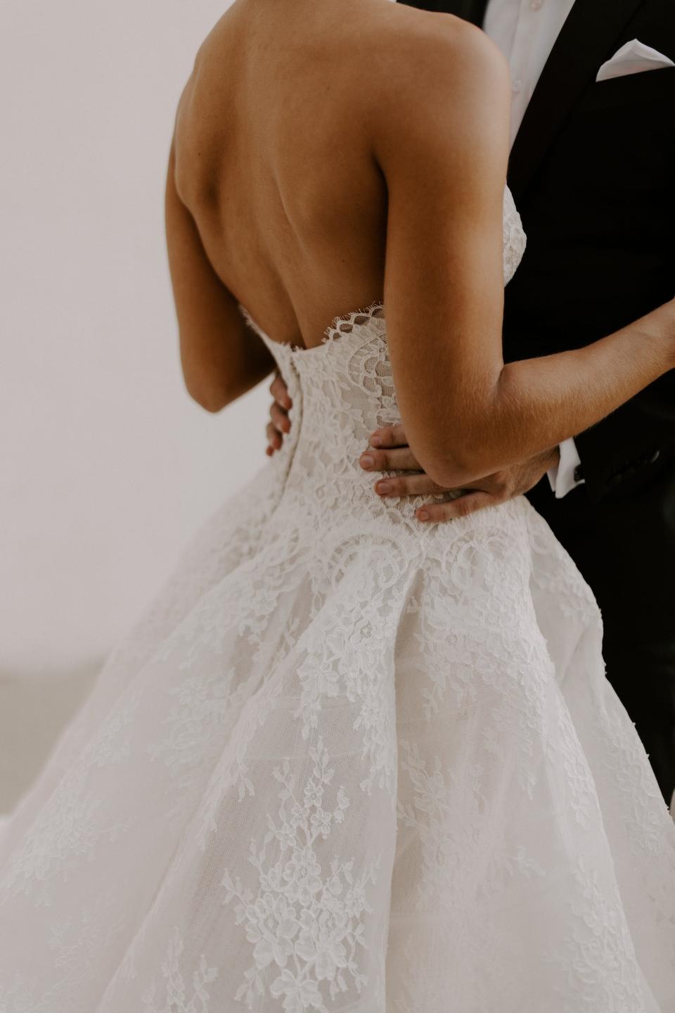 A close-up shot of the lace on the back of a bride's wedding dress.